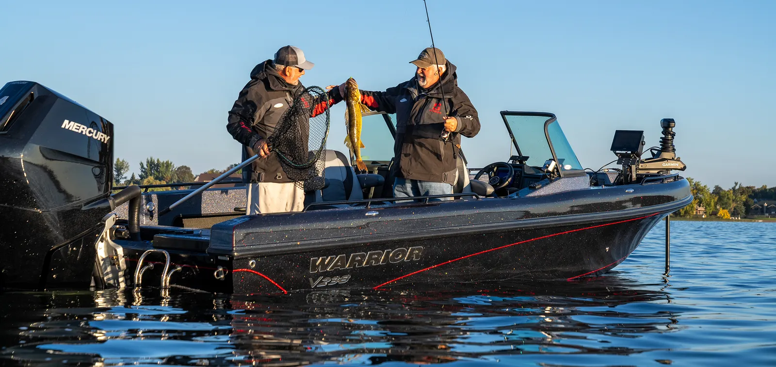 Two anglers landing a walleye aboard a Warrior V238 fiberglass boat